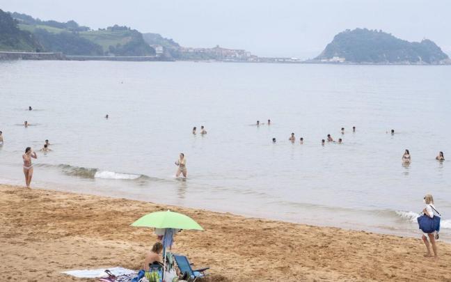Varias personas se dan un ba&ntilde;o en la playa de Zarautz