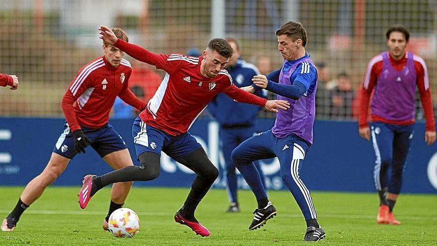 Kike Barja trata de zafarse de la marca de Bittor Alkiza, segundo entrenador de Osasuna, en Tajonar.