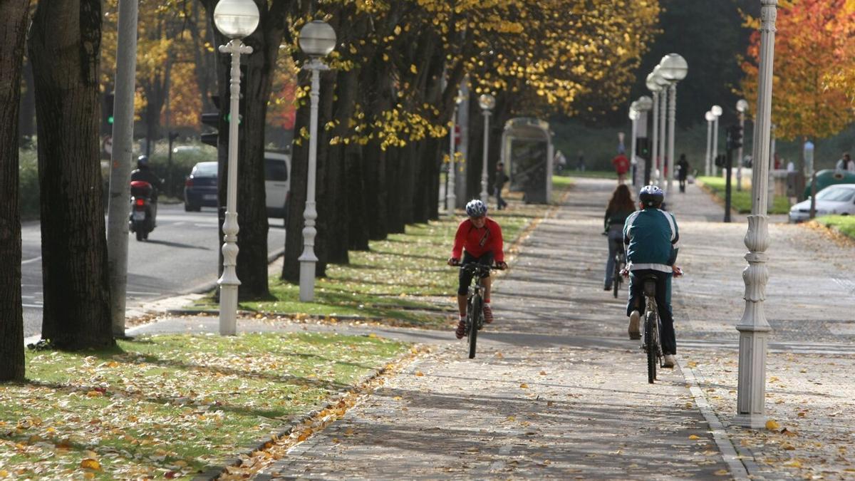 Varias personas, en bici, en un día otoñal en Donostia