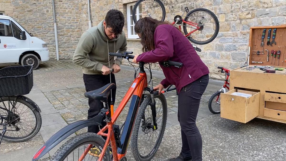 Imagen de dos personas reparando una bici