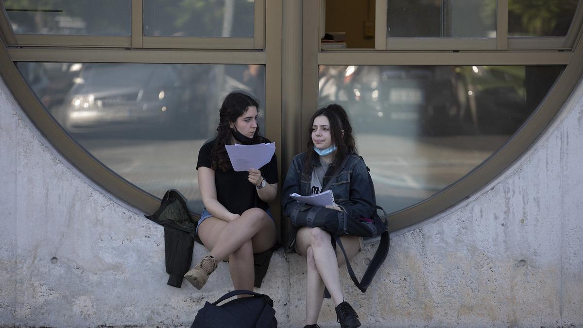 Dos estudiantes repasan apuntes ates de hacer la EvAU.