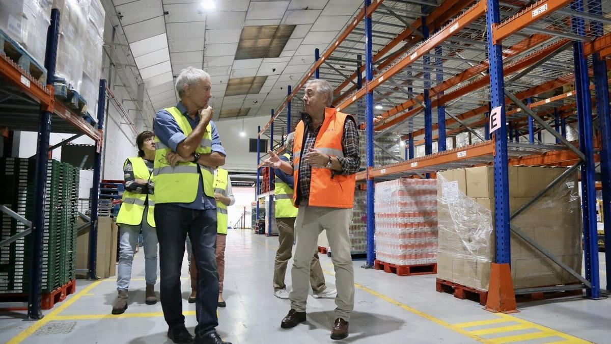 El vicepresidente del Banco de Alimentos de Gipuzkoa, Carlos Martínez, explica durante la visita al almacén de Oiartzun los pormenores de la Gran Recogida a Enrique Cifuentes, presidente del CD Fortuna.