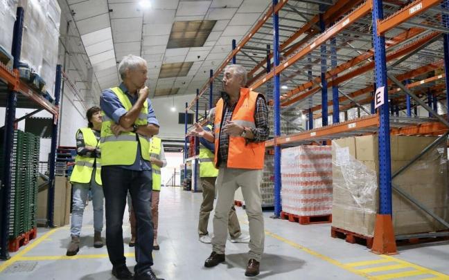 El vicepresidente del Banco de Alimentos de Gipuzkoa, Carlos Martínez, explica durante la visita al almacén de Oiartzun los pormenores de la Gran Recogida a Enrique Cifuentes, presidente del CD Fortuna.