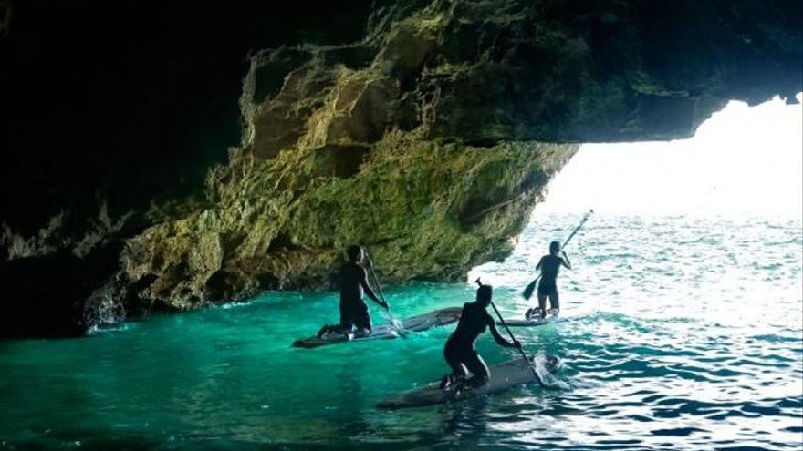 Bañistas disfrutan de la cueva del Llop Marí.