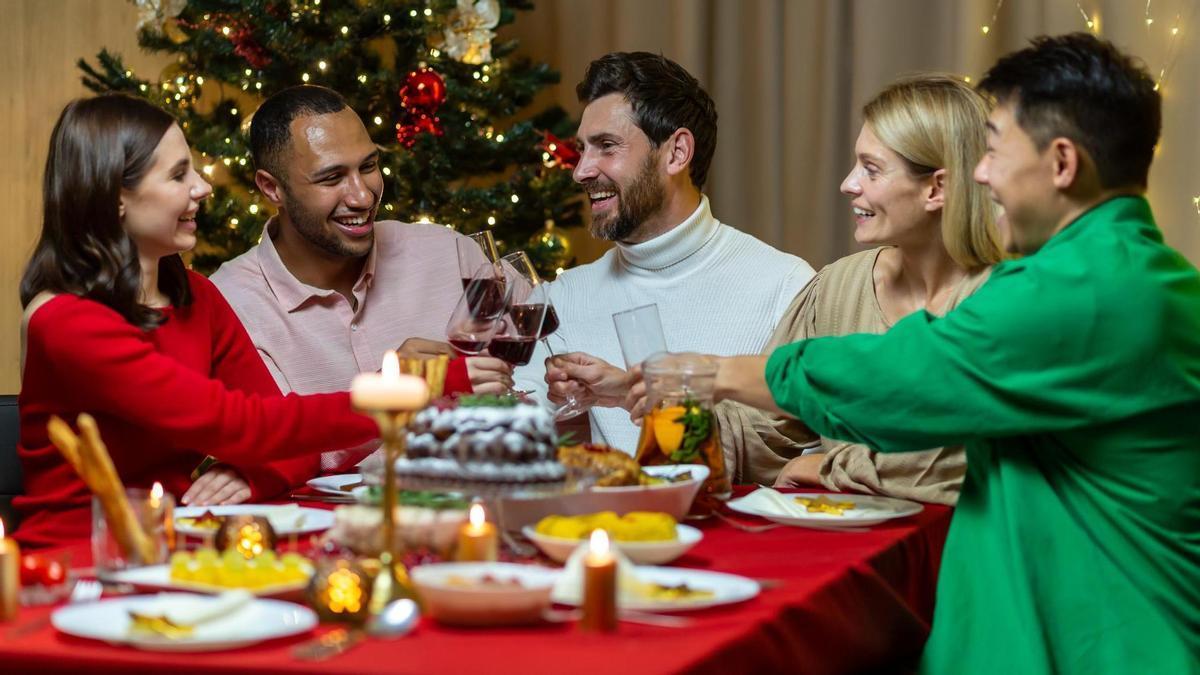 Un grupo de amigos y amigas cenan juntos en Navidad.