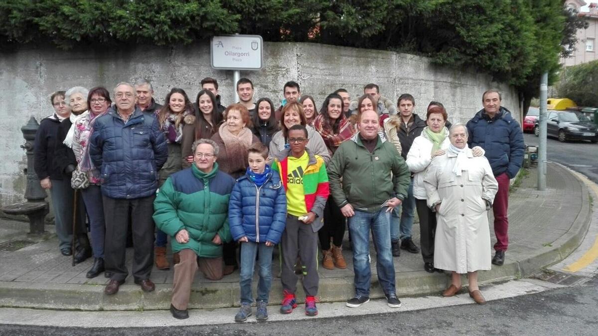 Vecinos y miembros de la asociación cultural posan ante la placa que en 2016 dedicaba la plaza de Kotarro a Oilargorri Elkartea.