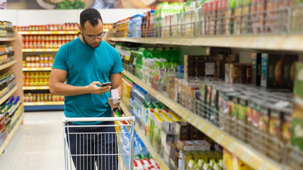 Un hombre revisa un producto en un supermercado.