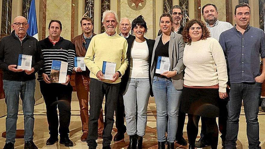 Miembros de las tamborradas más antiguas, de los txistularis y del Orfeón, con las placas por su participación en el Día de San Sebastián.