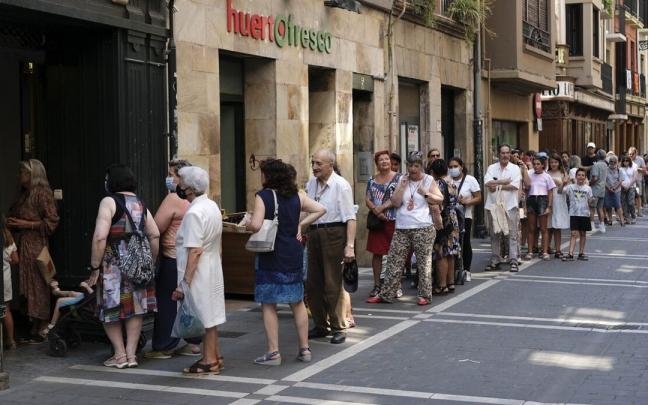Personas haciendo cola en la calle San Antón para recoger sus premios.