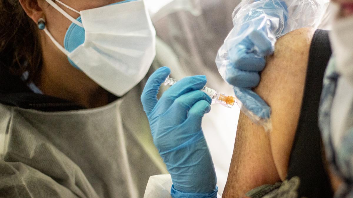 Una enfermera inyecta la vacuna contra la gripe a un paciente.