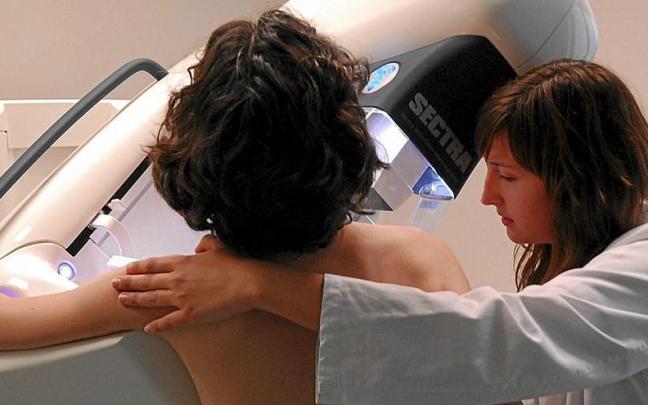 Una mujer se somete a una mamografía. Una mujer se somete a una mamografía.