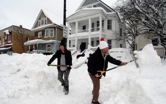 Los vecinos de una calle de Búfalo tratan de abrir un camino en la nieve. Los vecinos de una calle de Búfalo tratan de abrir un camino en la nieve.