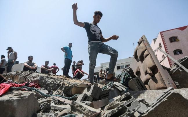Ciudadanos palestinos observan un edificio destruido por Israel en Gaza