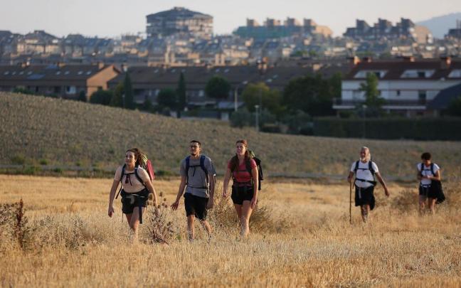 Peregrinos realizando el Camino de Santiago con Zizur al fondo. Peregrinos realizando el Camino de Santiago con Zizur al fondo.
