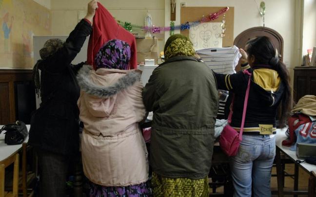 Varias mujeresinmigrantes buscan ropa en una parroquia de Vitoria.