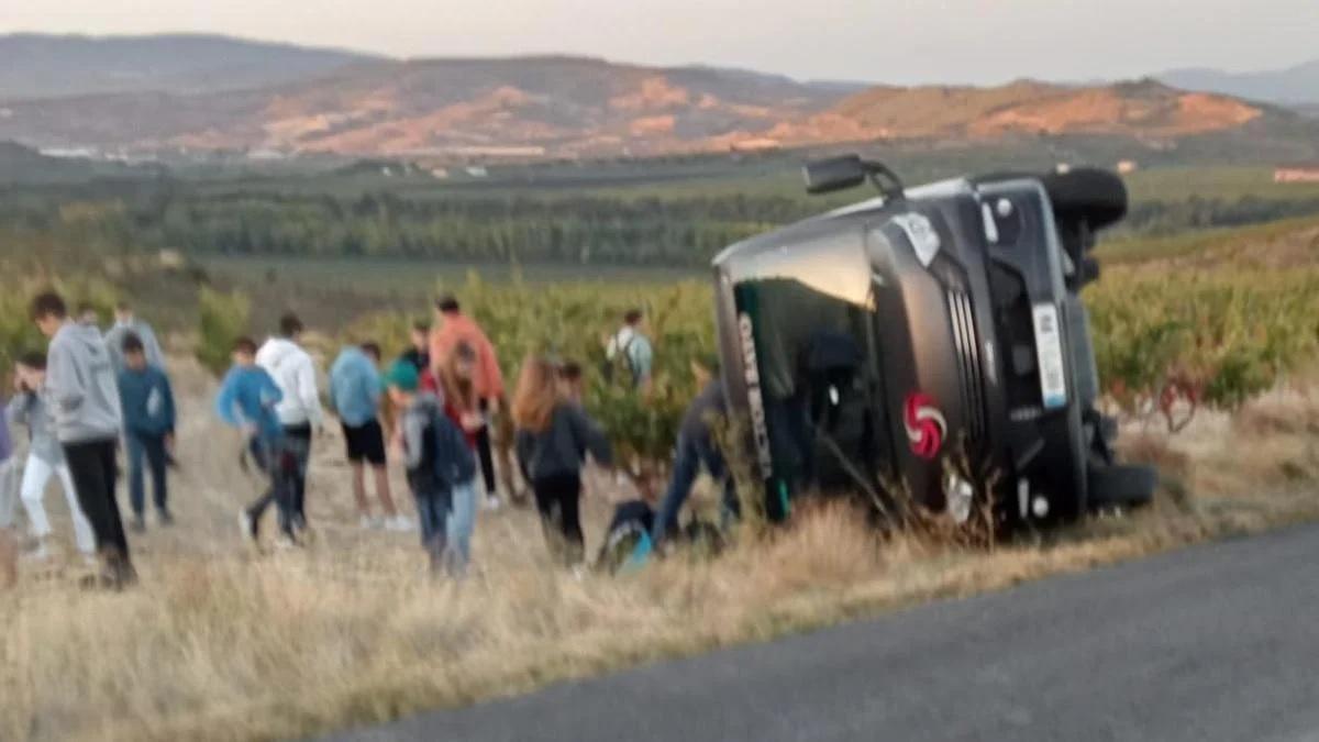 Los alumnos de la ikastola de Lapuebla de Labarca que viajaban en el autobús volcado esperan junto al vehículo tras el accidente