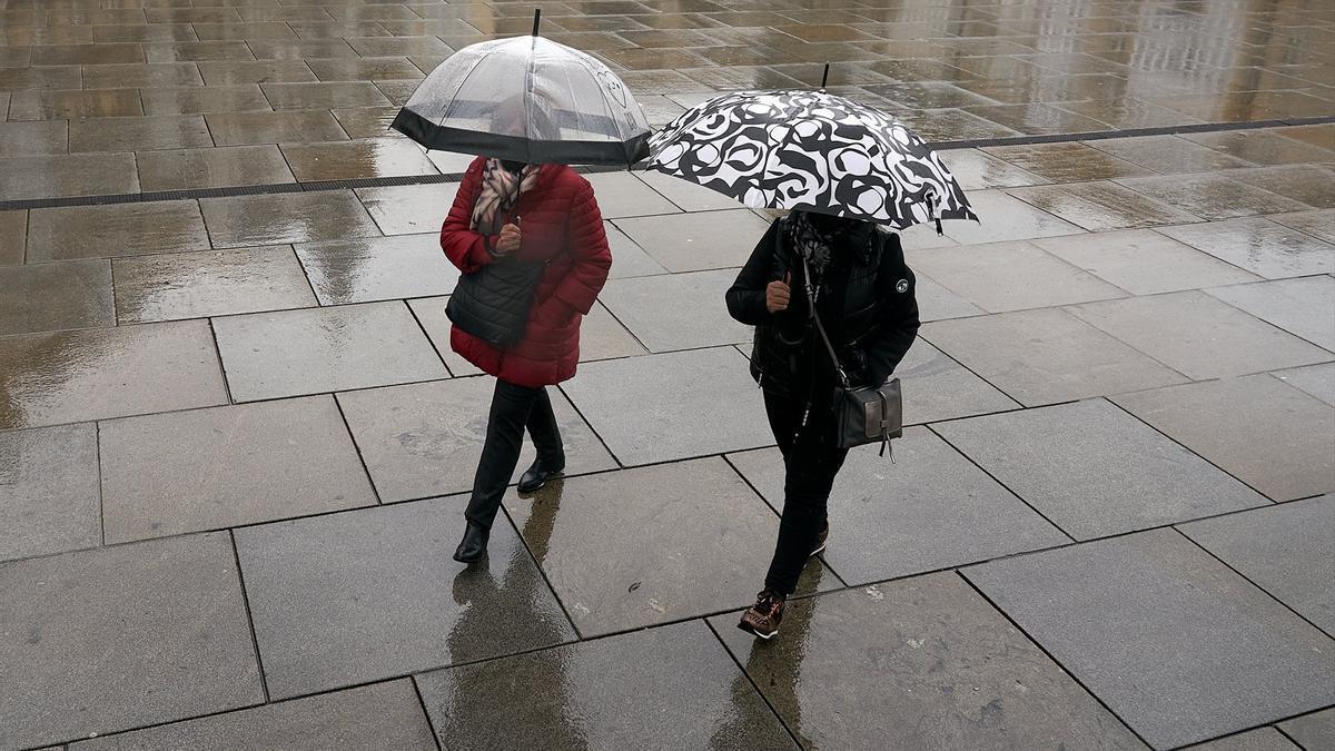 Dos personas caminando en un día lluvioso.