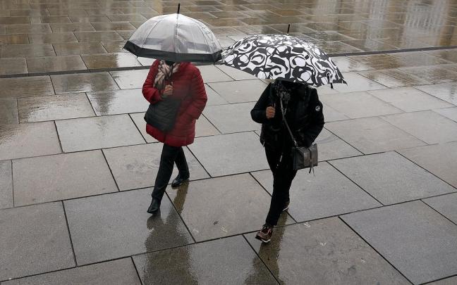 Dos personas caminando en un día lluvioso.