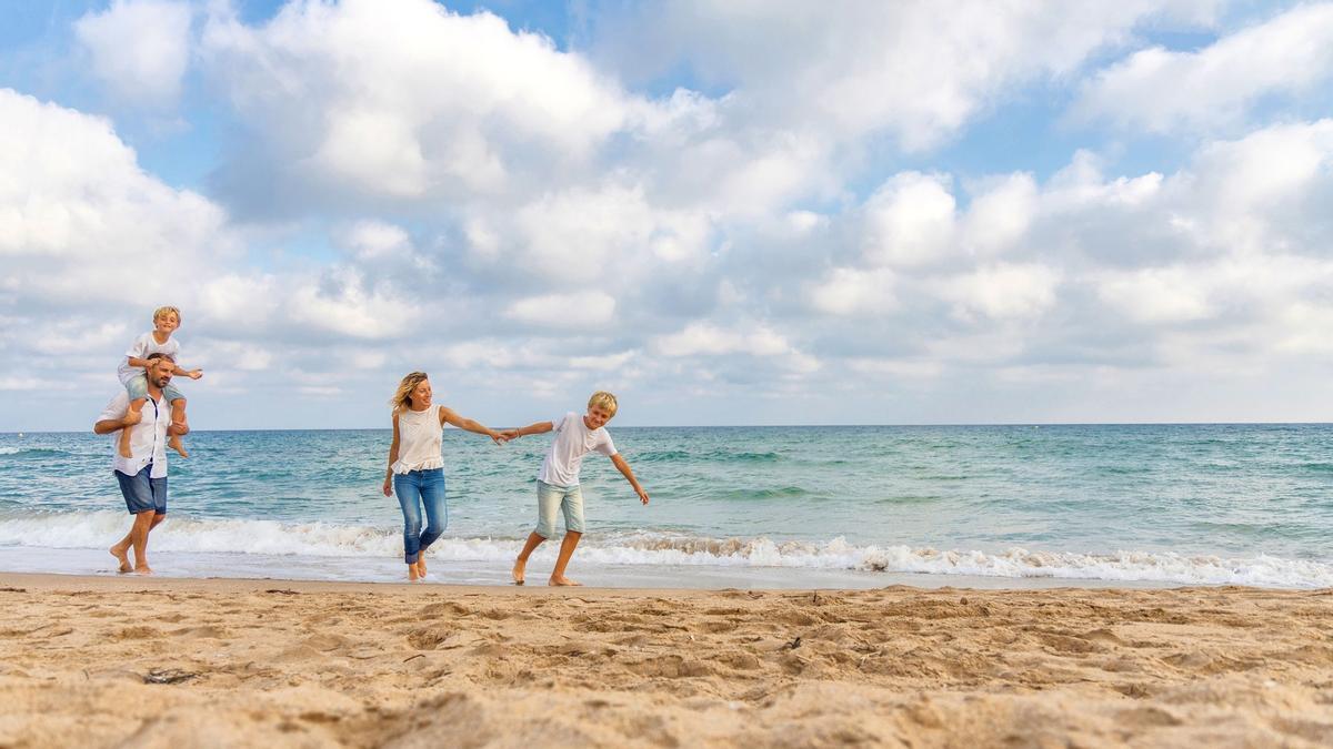 Familia paseando por la playa de Creixell (Tarragona)