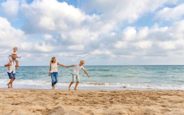 Familia paseando por la playa de Creixell (Tarragona)