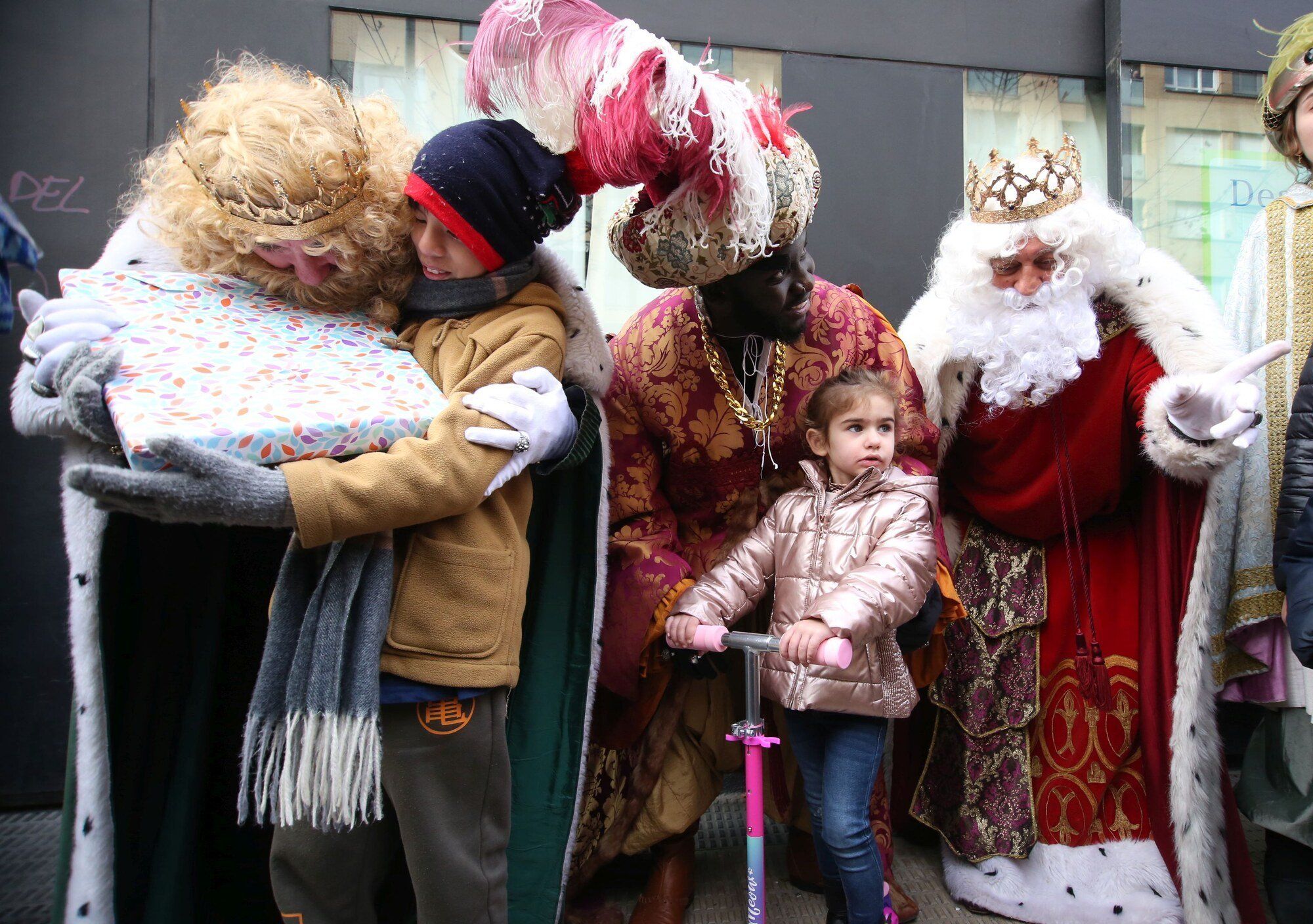 Gaspar, Baltasar y Melchor regalan juguetes a un niño y una niña.