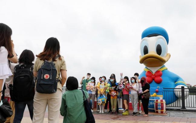 Turistas posan para una foto en el Disney Resort de Shanghái. Turistas posan para una foto en el Disney Resort de Shanghái.