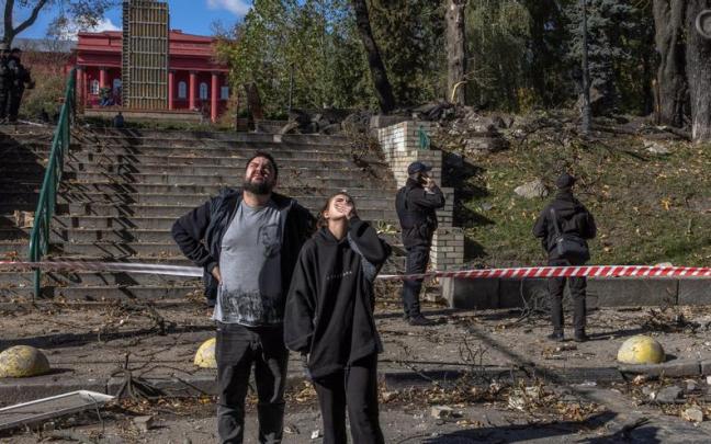 Varias personas en una calle de Kiev tras la caída de un misil lanzado por Rusia.