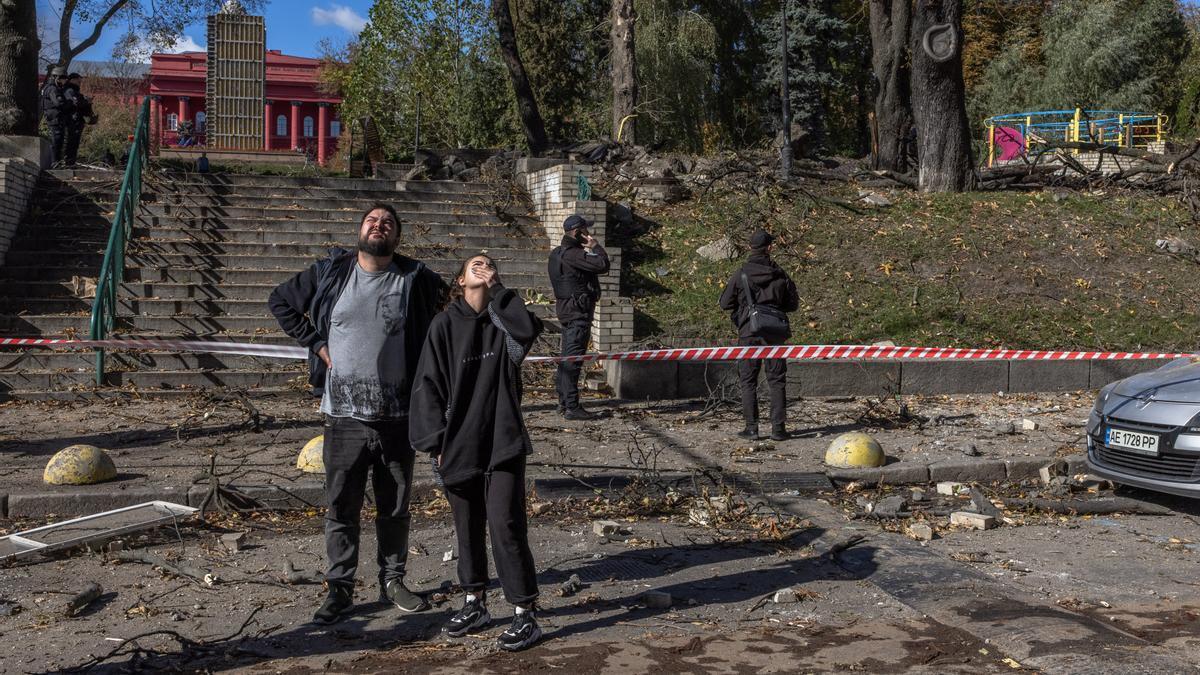 Varias personas en una calle de Kiev tras la caída de uno de los misiles lanzados por Rusia