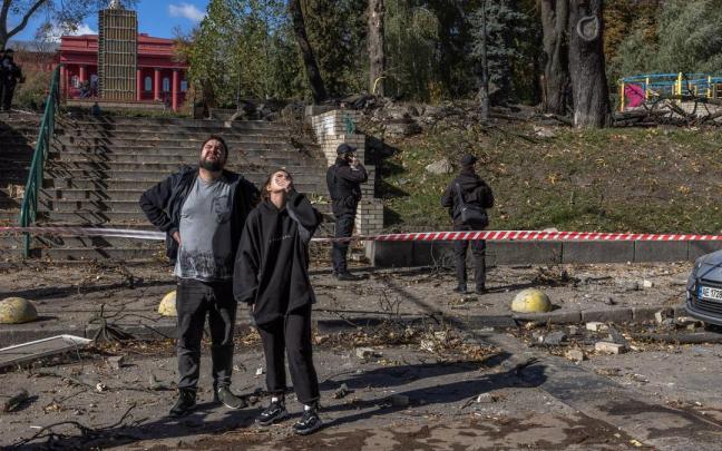 Varias personas en una calle de Kiev tras la caída de uno de los misiles lanzados por Rusia