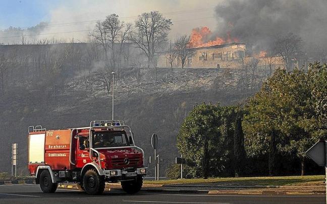 Un cami&oacute;n de Bomberos y, detr&aacute;s, el incendio del monte Ezkaba registrado en septiembre.