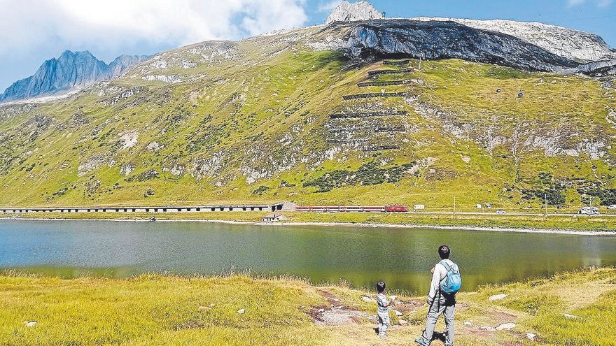 Argazkian, mendiak eta trena Oberalpsee lakuaren ertzean.