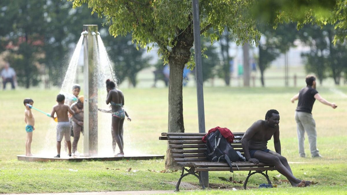 Varios niños se refrescan en una ducha de Bilbao durante la pasada ola de calor