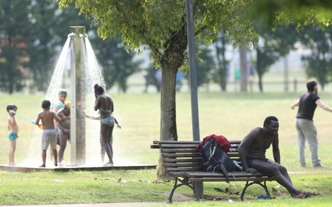 Varios ni&ntilde;os se refrescan en una ducha de Bilbao durante la pasada ola de calor