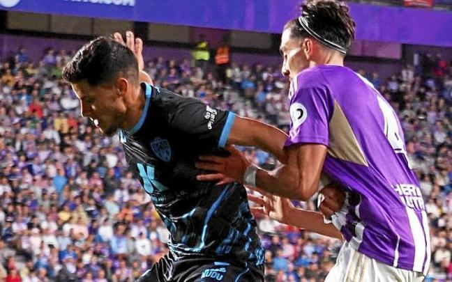 Robertone protege el balón del acoso de Kike Pérez.