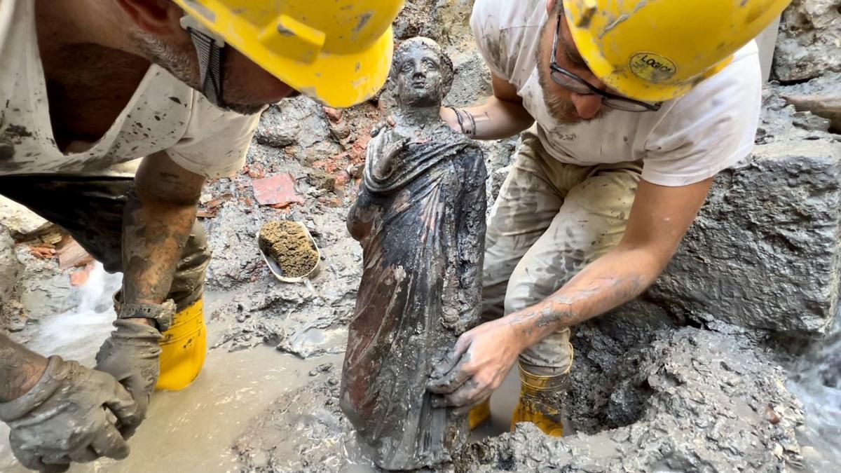 Una estatua es sacada del barro durante las excavaciones en San Casciano dei Bagni.