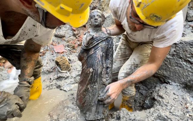 Una estatua es sacada del barro durante las excavaciones en San Casciano dei Bagni.