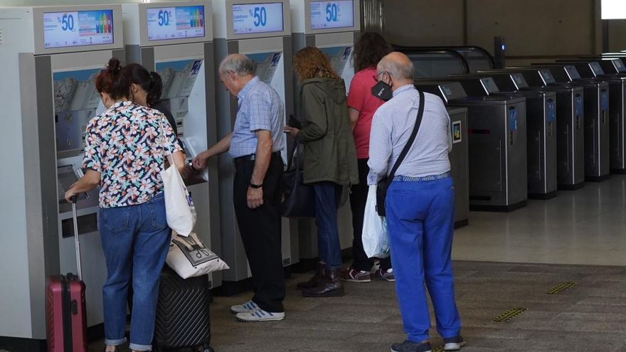 Varias personas junto a las máquinas para la venta de títulos de transporte.