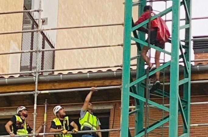 González, sin casco, habla con un joven que se encaramó a una grúa en junio de 2021.