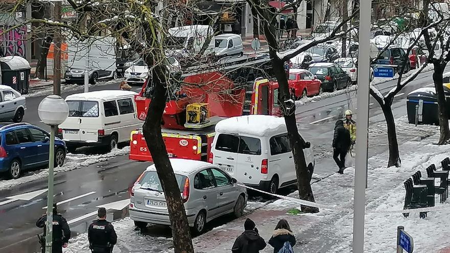 Los bomberos retiran nieve de las cornisas en la Avenida