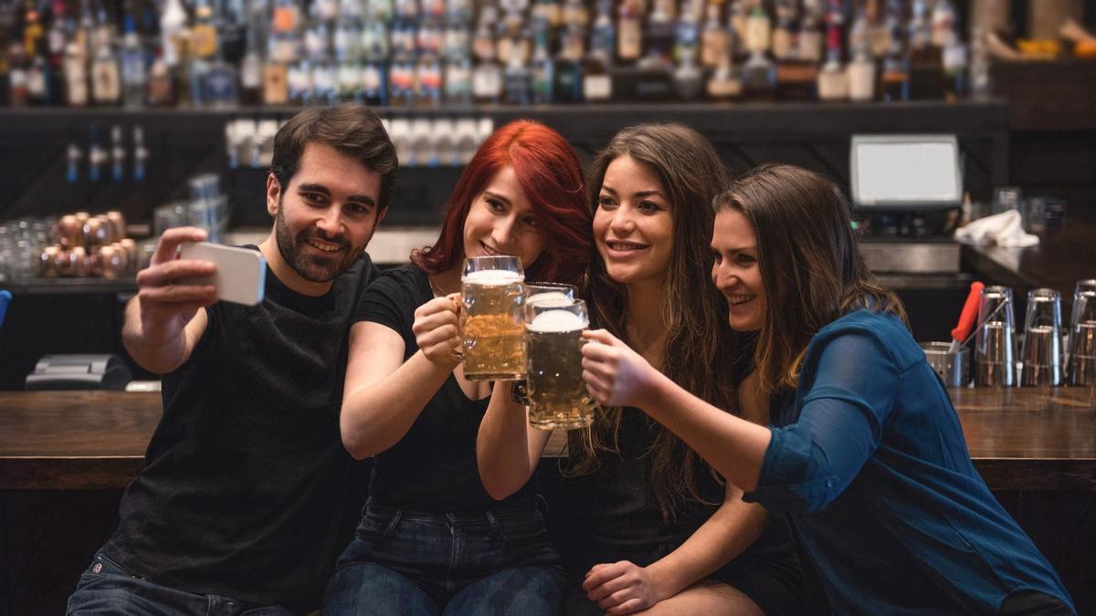 Un grupo de amigos bebe cerveza en un bar.