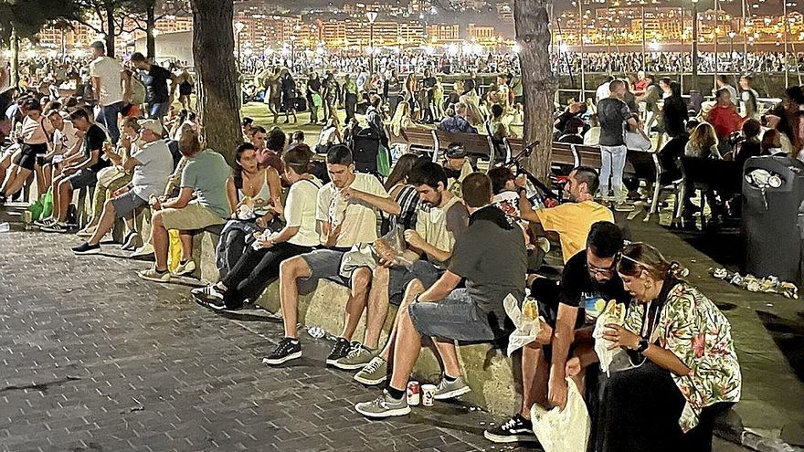 Cientos de personas comiendo sus bocadillos o platos para llevar en el puerto de Donostia.