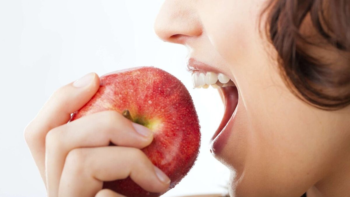 Detalle de una joven comiendo una manzana Detalle de una joven comiendo una manzana