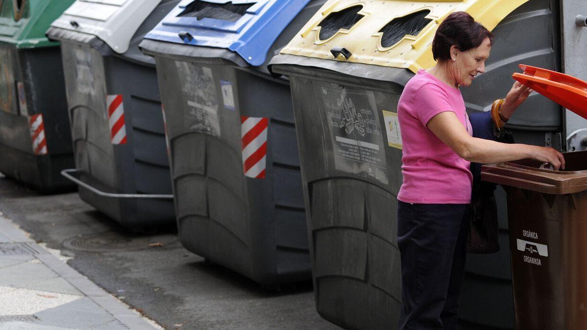 Una mujer, ajena a la información, utiliza el contenedor de residuos orgánicos