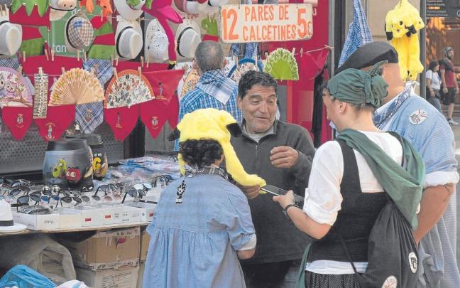 Un niño se prueba un llamativo gorro en un puesto de venta ambulante. Un niño se prueba un llamativo gorro en un puesto de venta ambulante.