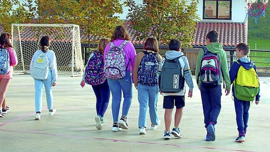 Jóvenes pasean a la salida de un centro escolar.