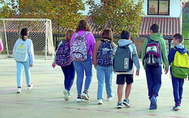 J&oacute;venes pasean a la salida de un centro escolar.