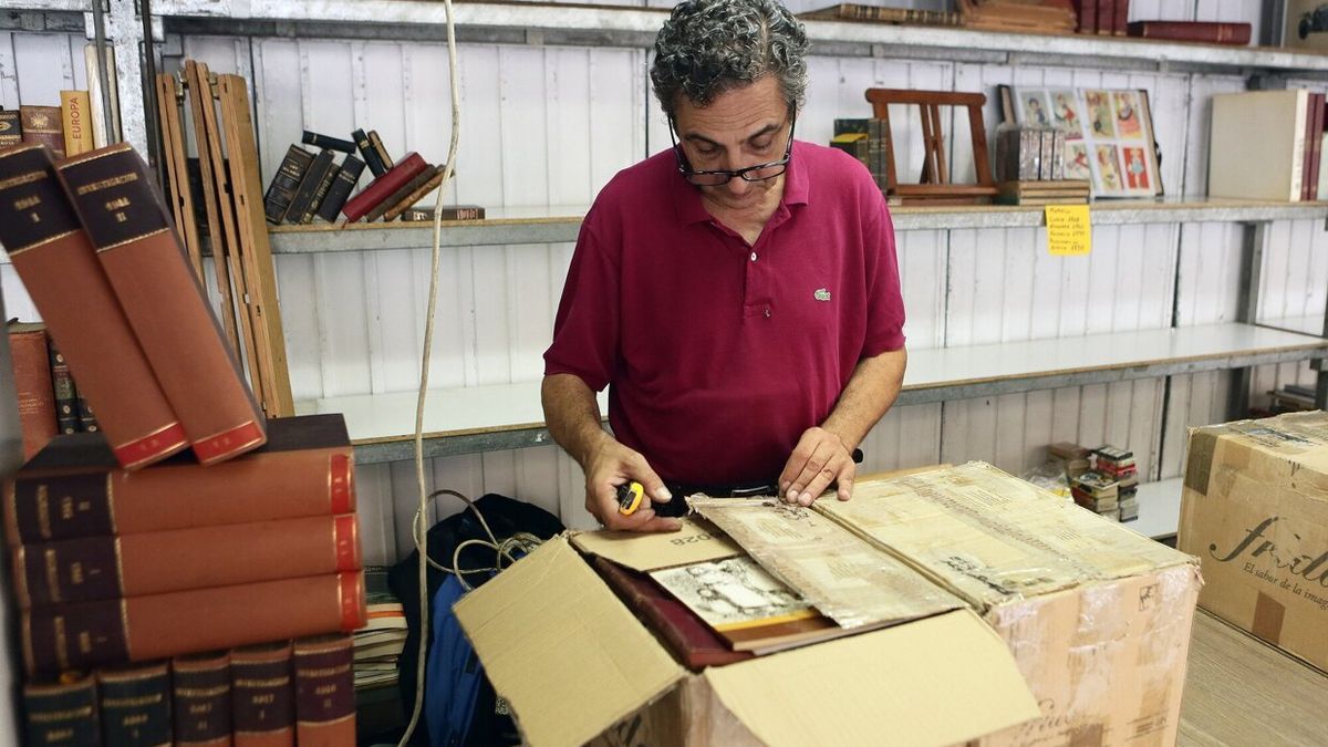 Un vendedor prepara su puesto de libros para la apertura de mañana.