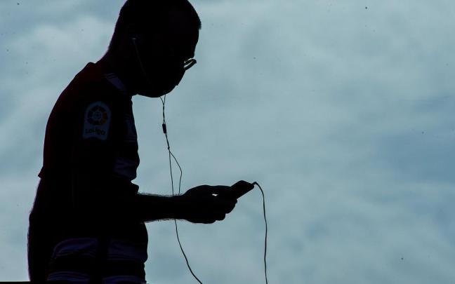 Un hombre escucha la radio en un campo de f&uacute;tbol.