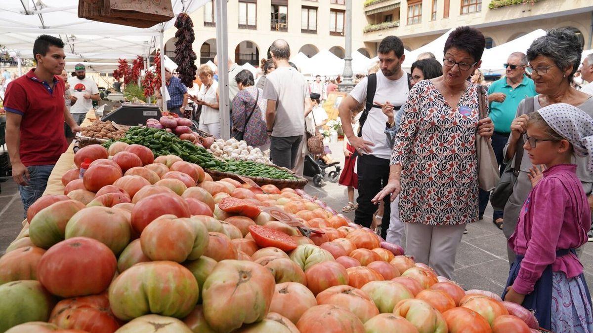 Unas personas contemplando uno de los puesto de fruta y hortalizas instalado el la plaza Jose Miguel Barandiaran de Ordizia, en la Feria Extraordinaria de Euskal Jaiak