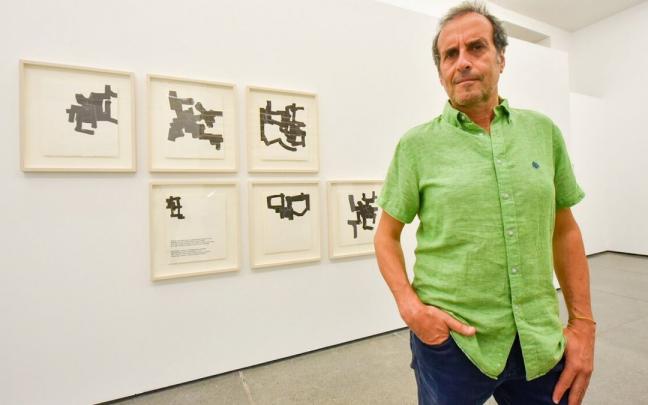 El director de la galer&iacute;a Altxerri, Javier Balda, posa frente a unas l&aacute;minas de Eduardo Chillida.